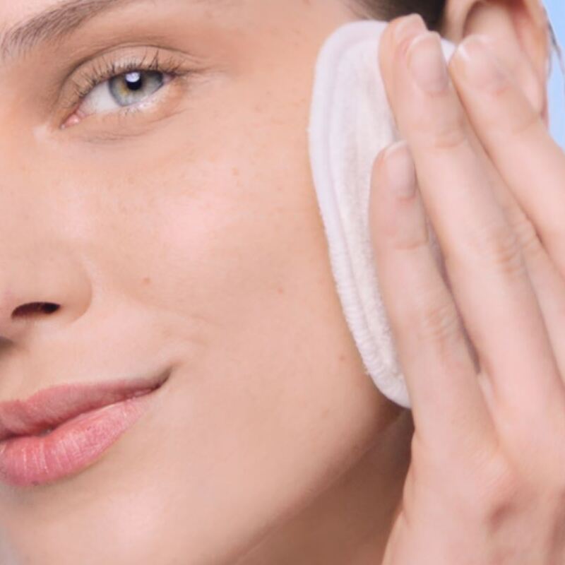 Femme nettoyant sa peau avec de l’eau micellaire