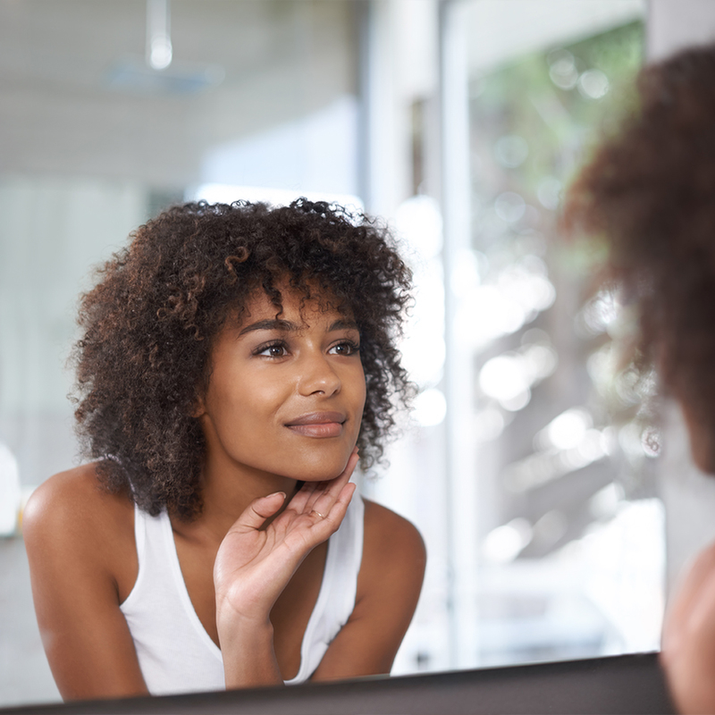 Femme dans le miroir avec des taches brunes