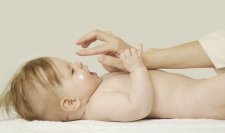 Une maman met de la crème à son bébé