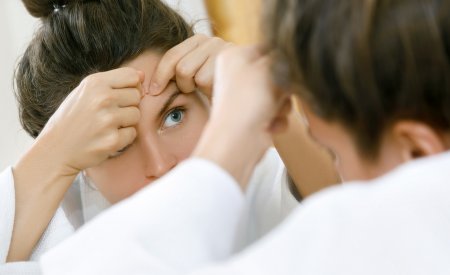 Une femme se perce un bouton