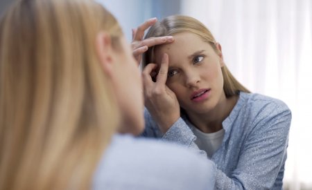 Une femme se perce les boutons d'acné