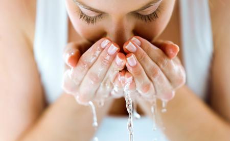 Une femme se lave le visage