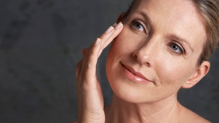Une femme mature qui s'applique de la crème