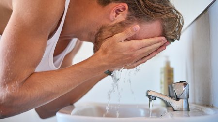 Une homme se lave le visage