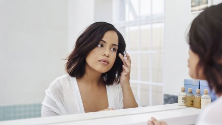 Une femme applique des soins hydratants sur son visage