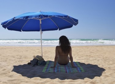 Une femme sous un parasol sur la plage