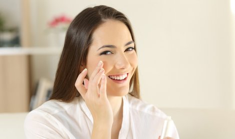 Une femme hydrate sa peau sèche